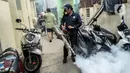 Petugas melakukan pengasapan (fogging) untuk memberantas perkembangbiakkan nyamuk Demam Berdarah Dengue (DBD) di pemukiman padat penduduk, Jakarta, Rabu (18/5/2022). Menghadapi musim pancaroba yang menjadi perkembangbiakkan nyamuk Aedes Agypty penyebab penyakit DBD, warga melakukan fogging di wilayah padat penduduk. (Liputan6.com/JohanTallo)