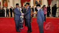 Presiden Joko Widodo menyalami Ketua dan anggota pimpinan sementara KPK, Taufiequrrachman Ruki usai pelantikan di Istana Negara, Jakarta, Jumat (20/2/2015). (Liputan6.com/Faizal Fanani) 