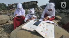 Siswa kelas 3 SDN II Roda Kota Bogor dan pendamping belajar kelompok secara daring di pinggir sungai Ciliwung, Kampung Kebon Jukut RT 01/10, Babakan Pasar, Kamis (6/8/2020). Belajar di pinggir sungai Ciliwung itu guna mendapatkan jaringan internet yang baik di masa pandemi. (merdeka.com/Arie Basuki)