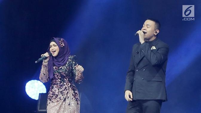 Penyanyi Siti Nurhaliza (kiri) berduet dengan Tulus dalam konser 'Dato Sri Siti Nurhaliza on Tour' di Istora Senayan, Jakarta, Kamis (21/2). Suara tepuk tangan dan teriakan penonton terdengar di tengah duet. (Fimela.com/Bambang E Ros)