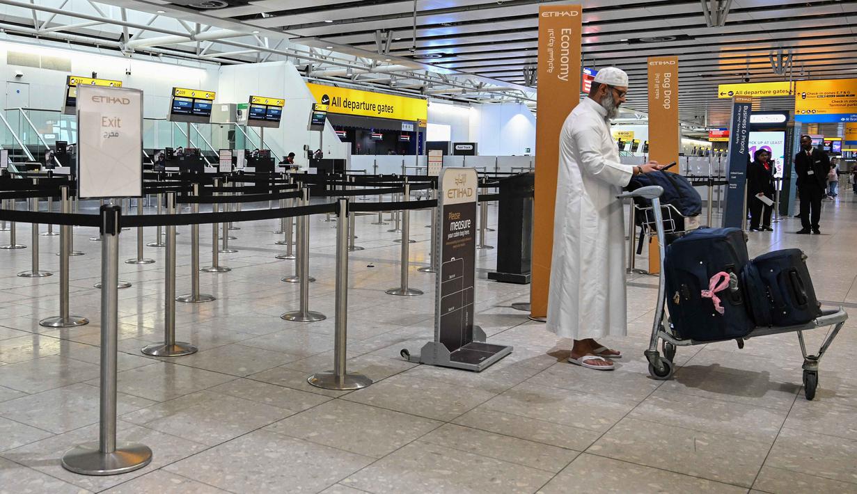 Diketahui, setidaknya ada delapan negara di kawasan Timur Tengah menyatakan menutup wilayah udaranya. Tampak dalam foto, seorang pria berdiri di depan konter check-in yang tutup milik maskapai penerbangan Etihad di Bandara Heathrow, London pada Minggu 1 Maret 2026. (JUSTIN TALLIS/AFP)