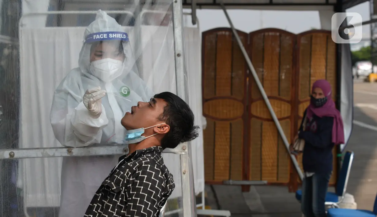 Petugas melakukan swab test antigen kepada pemudik saat arus balik Lebaran di Terminal Pulogebang, Jakarta, Jumat (21/5/2021). Satu minggu setelah Lebaran, pemudik yang tiba di Terminal Pulogebang wajib menjalani tes COVID-19. (merdeka.com/Imam Buhori)