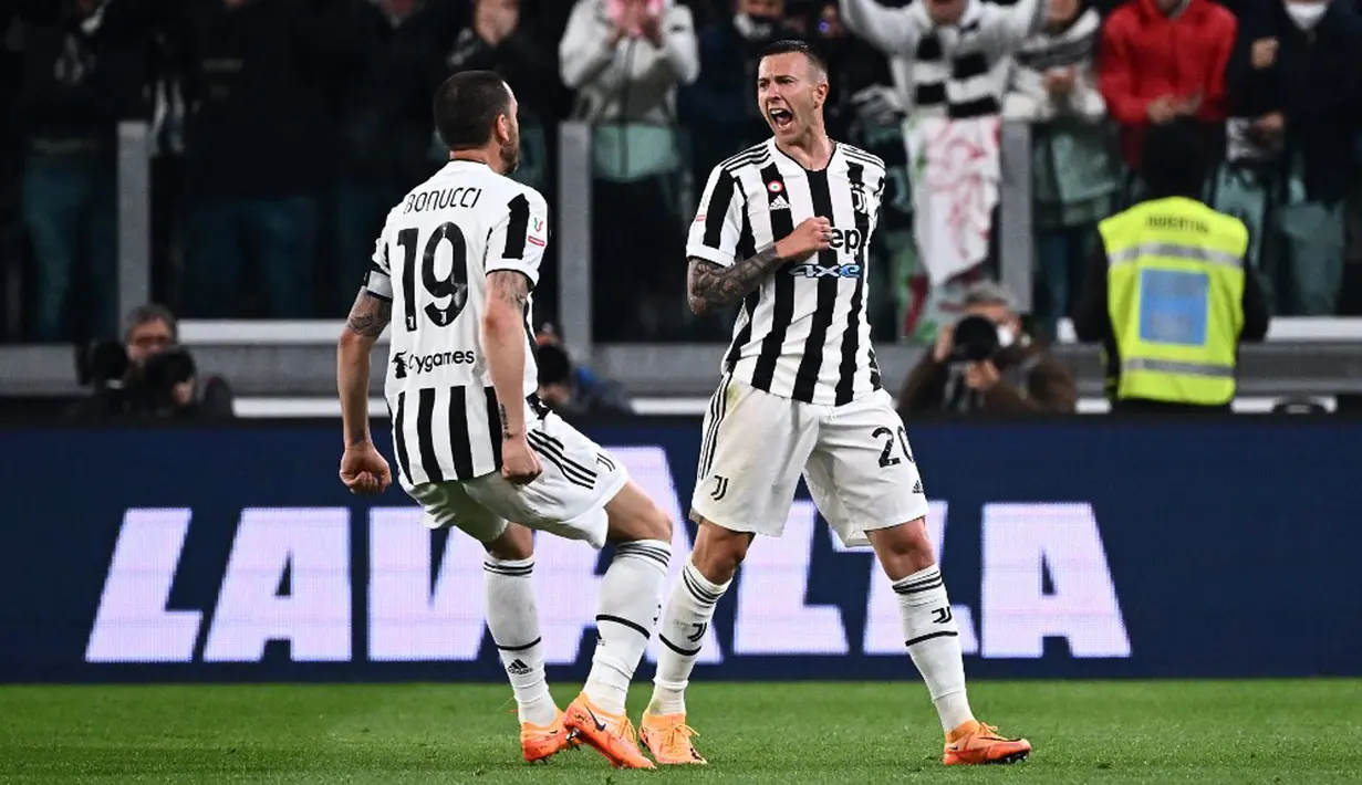 Pemain Juventus Federico Bernardeschi melakukan selebrasi dengan Leonardo Bonucci (kiri) usai mencetak gol ke gawang Fiorentina pada pertandingan leg kedua semifinal Coppa Italia di Stadion Juventus, Turin, Italia, 20 April 2022. Juventus menang 2-0. (Marco BERTORELLO/AFP)