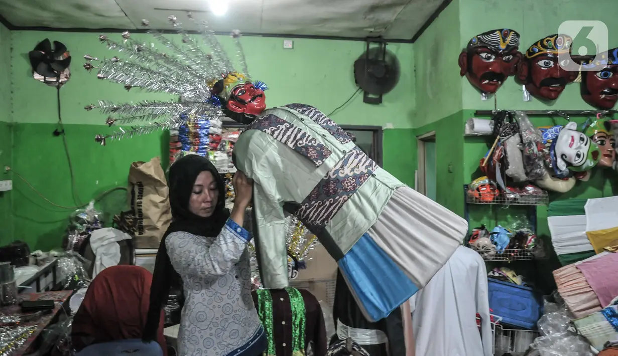 Pengrajin menyelesaikan produksi miniatur ondel-ondel di industri rumahan kesenian Betawi Raja Ondel-Ondel, Pasar Minggu, Jakarta, Senin (13/12/2021). Data Kemenkop UKM mencatat realisasi penyaluran KUR kepada UMKM hingga November 2021 sebesar Rp 262,95 triliun. (merdeka.com/Iqbal S. Nugroho)