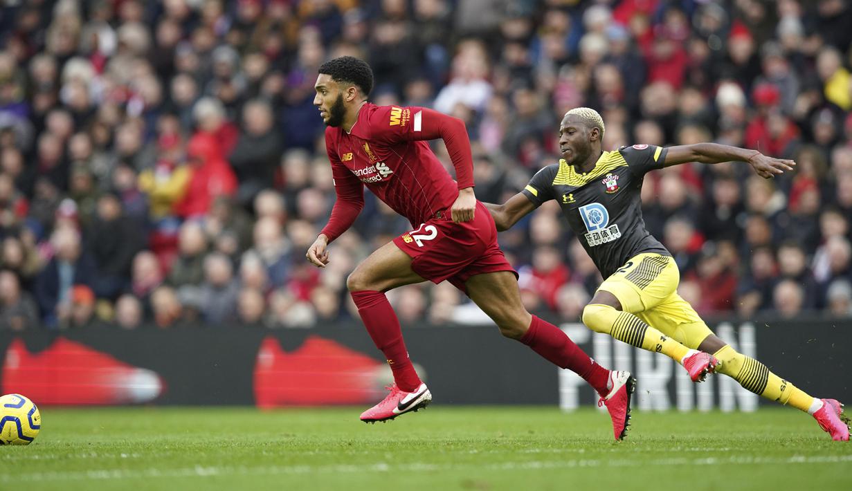 Bek Liverpool, Joe Gomez membawa bola dari kejaran gelandang Southampton, Moussa Djenepo pada pertandingan lanjutan Liga Inggris di Stadion Anfield, Sabtu (1/2/2020). Liverpool menang telak 4-0 atas Southampton. (AP Photo/Jon Super)