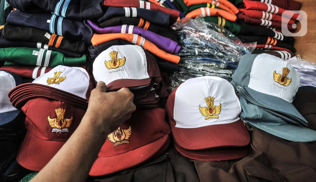 Calon pembeli saat memilih topi sekolah di Pasar Mester Jatinegara, Jakarta Timur, Senin (3/1/2022). Salah satu pedagang mengungkapkan penjualan seragam sekolah mengalami peningkatan 50 persen seiring pemberlakuan PTM di Jakarta yang kembali digelar 100 persen. (merdeka.com/Iqbal S. Nugroho)