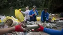 Para sukarelawan menyortir sampah yang terkumpul setelah mereka tiba di lokasi perkemahan pada hari Selasa, 1 Agustus 2023. (AP Photo/Denes Erdos)