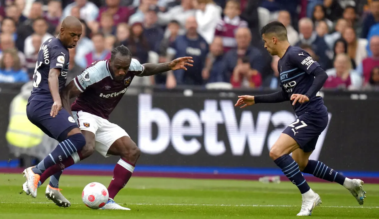 Pemain Manchester City Fernandinho (kiri) mencoba untuk menjegal pemain West Ham United Michail Antonio (tengah) pada pertandingan sepak bola Liga Inggris di London Stadium, London, Inggris, 15 Mei 2022. Pertandingan berakhir imbang 2-2. (AP Photo/Kirsty Wigglesworth)
