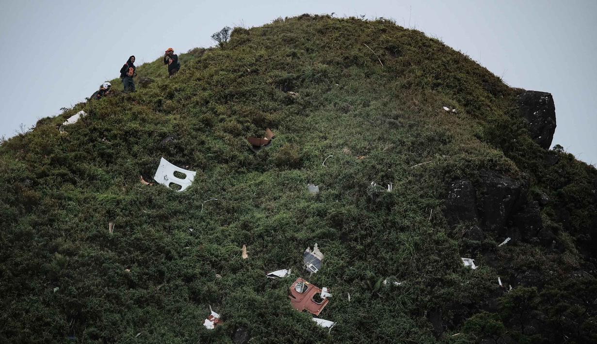 Apabila cuaca memburuk, jalur darat menjadi alternatif bagi tim gabungan untuk menjangkau lokasi. Tampak dalam foto, personel pencarian dan penyelamatan bersiap untuk membawa puing-puing pesawat turboprop Indonesia Air Transport berjenis ATR 42-500 di Gunung Bulusaraung, Sulawesi Selatan pada Minggu 18 Januari 2026. (Muchtamir Zaide/AFP)