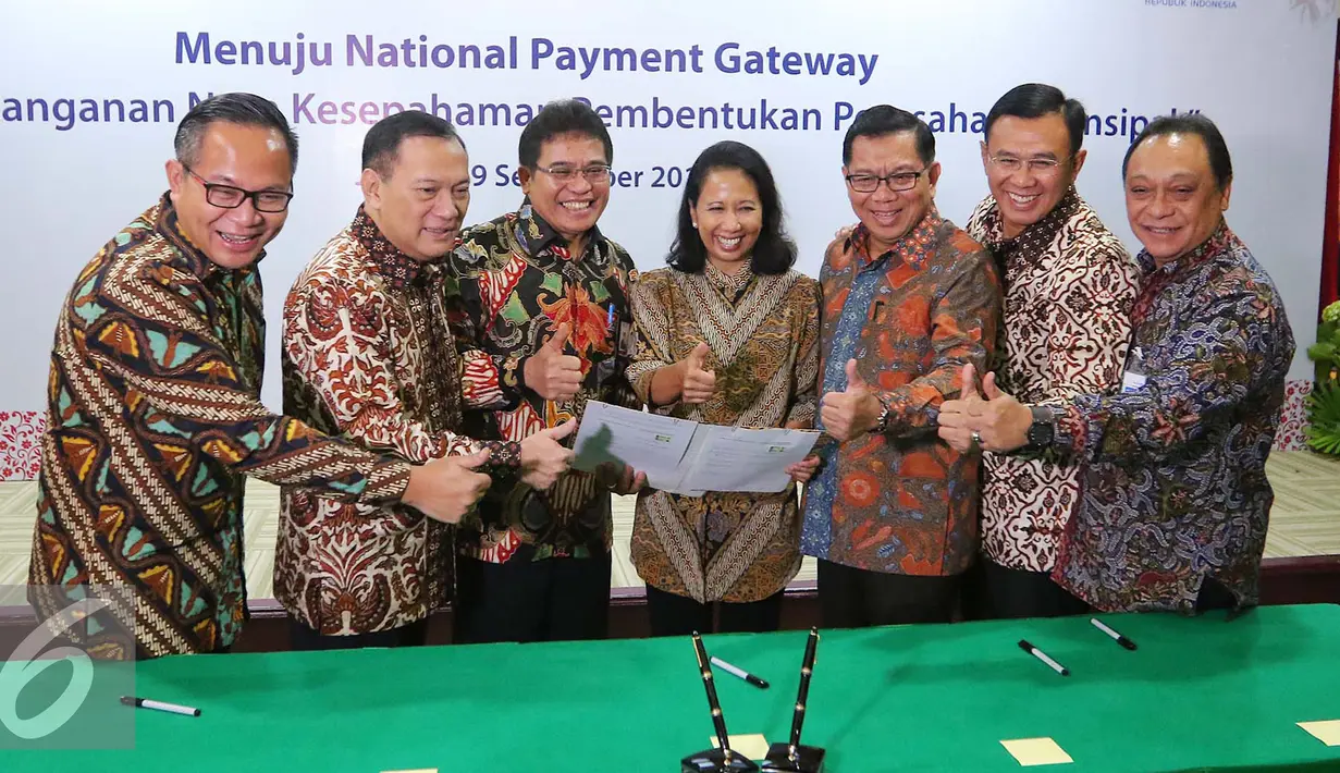 Menteri BUMN Rini Soemarno (tengah) bersama Gubernur BI Agus Martowardojo dan sejumlah Dirut Bank BUMN tengah memegang naskah MoU sinergi pembentukan perusahaan prinsipal di Jakarta, Jumat (9/9). (Liputan6.com/Angga Yuniar)