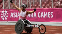 Pebalap kursi roda Indonesia, Jaenal Aripin, melakukan selebrasi usai meraih medali perak pada Asian Para Games cabang atletik nomor balap kursi roda 200 meter T 54 di SUGBK, Jakarta, Jumat (12/10). (Bola.com/Vitalis Yogi Trisna)