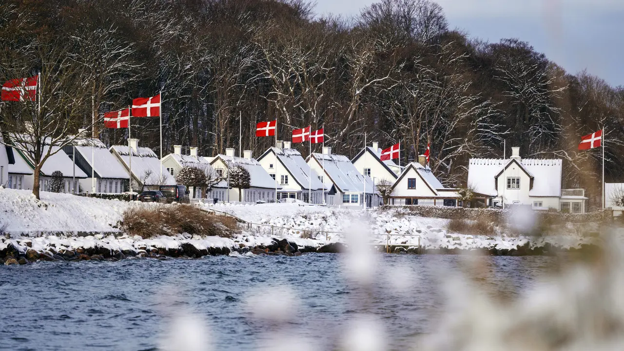 Rumah-rumah berbendera nasional Denmark terlihat di Humlebaek, utara Kopenhagen, Denmark setelah hujan salju pada 29 November 2023.