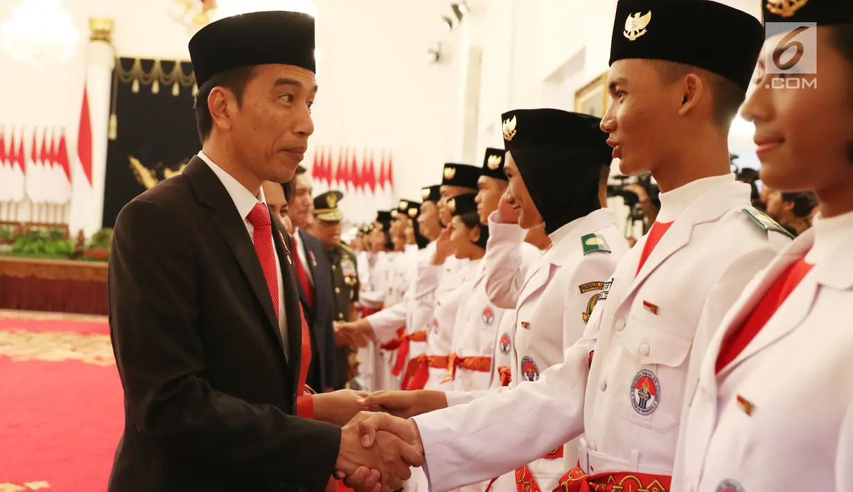 Presiden Jokowi bersalaman dengan anggota Paskibraka Nasional 2017 saat pengukuhan di Istana Negara, Jakarta, Selasa (15/8). Paskibra ini nantinya akan mengibarkan bendera merah putih pada upacara peringatan HUT RI-ke 72. (Liputan6.com/Angga Yuniar)