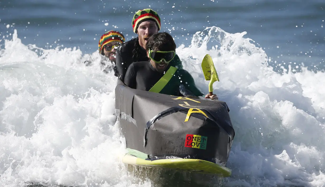 Peserta memodifikasi papan selancarnya menjadi perahu dengan dandanan khas negara Jamaika di Santa Monica, Amerika Serikat, Sabtu (31/10/2015). Acara ini untuk merayakan hari Halloween yang jatuh tanggal 31 Oktober. (REUTERS/Lucy Nicholson)