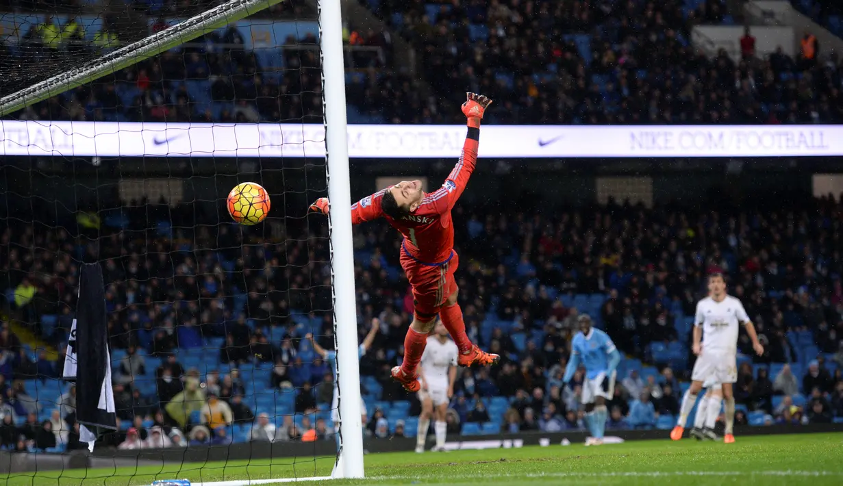Kiper Swansea City, Lukasz Fabianski, gagal menghalau bola tendangan pemain Manchester City dalam lanjutan Liga Inggris di Stadion Etihad, Manchester, Sabtu (12/12/2015). (AFP/Oli Scarff)