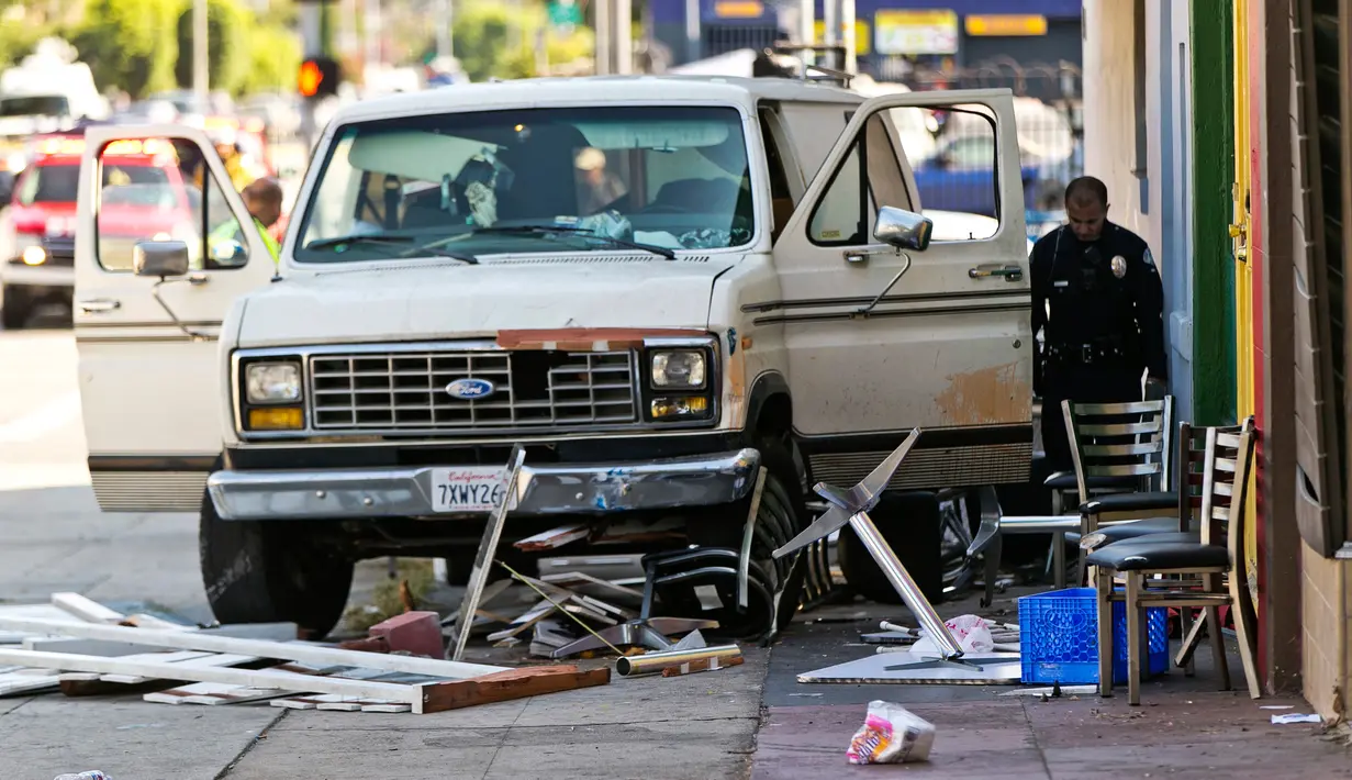 Petugas memeriksa mobil van yang menabrak kerumunan orang di depan sebuah restoran di Los Angeles, Amerika Serikat, Minggu (30/7). Setidaknya sembilan orang luka-luka dalam insiden itu, dengan salah seorang di antaranya kritis (AP Photo/Damian Dovarganes)