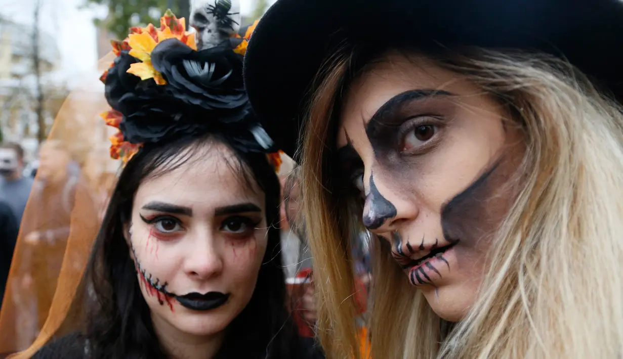 Dua orang perempuan berpose dengan dandanan menyerupai zombie ketika berpartisipasi dalam 'Zombie Walk' di pusat Kota Kiev, Ukraina, 26 Oktober 2019. Menjelang perayaan Halloween pada 31 Oktober mendatang, warga di beberapa belahan dunia sudah mulai melakukan acara bertema horor. (AP/Efrem Lukatsky)
