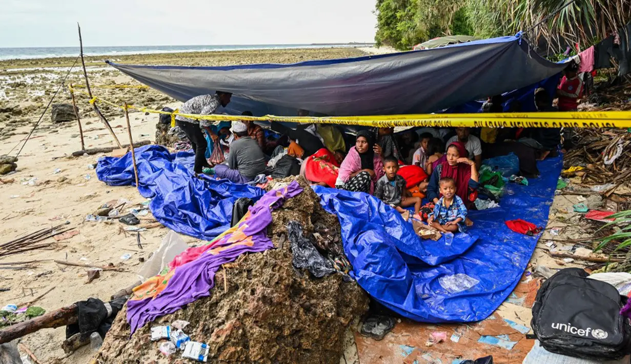 <p>Pengungsi Rohingya berkumpul dalam tenda di pantai di Pulau Sabang, Provinsi Aceh, Indonesia, Minggu (3/12/2023). Lebih dari 100 pengungsi Rohingya, termasuk perempuan dan anak-anak, mendarat di pantai Aceh pada tanggal 2 Desember 2023 dini hari. (CHAIDEER MAHYUDDIN/AFP)</p>