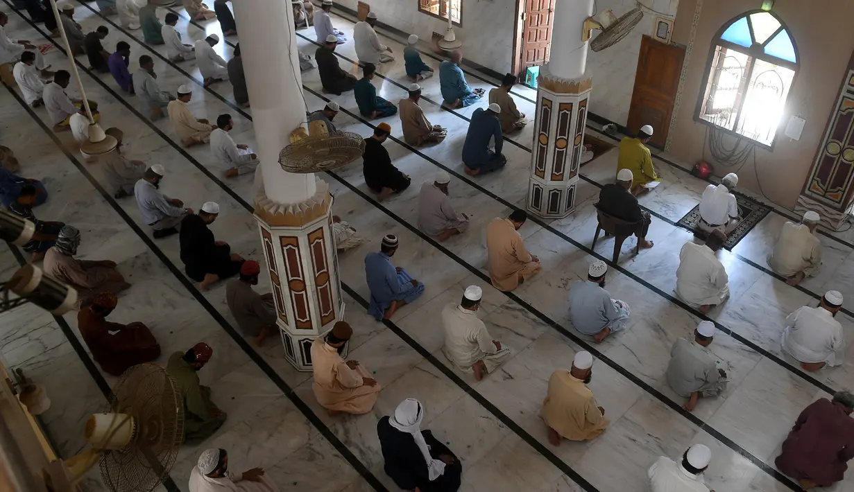 Umat muslim menerapkan jaga jarak aman atau physical distancing saat melaksanakan salat Jumat berjemaah selama Ramadan di sebuah masjid di Karachi, Pakistan, Jumat (1/5/2020). Umat muslim dunia melaksanakan Ramadan tahun ini di tengah pandemi COVID-19. (Asif HASSAN/AFP)