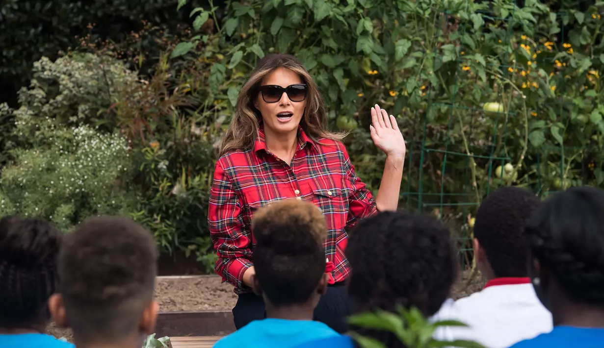 Ibu Negara AS, Melania Trump berbincang dengan anak-anak dari Boys & Girls Club saat menjadi tuan rumah acara berkebun di Kitchen Garden Gedung Putih, Jumat (22/9). Bukan Melania namanya jika tak selalu tampil totalitas dan fashionable (NICHOLAS KAMM/AFP)