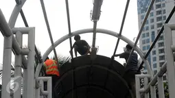 Pekerja melakukan penggantian atap Jembatan Penyebrangan Orang (JPO) di Jalan Kasblanca, Jakarta, Selasa (22/11). Pemerintah Provinsi DKI Jakarta menargetkan perbaikan JPO tak layak segera rampung. (Liputan6.com/Helmi Fithriansyah)