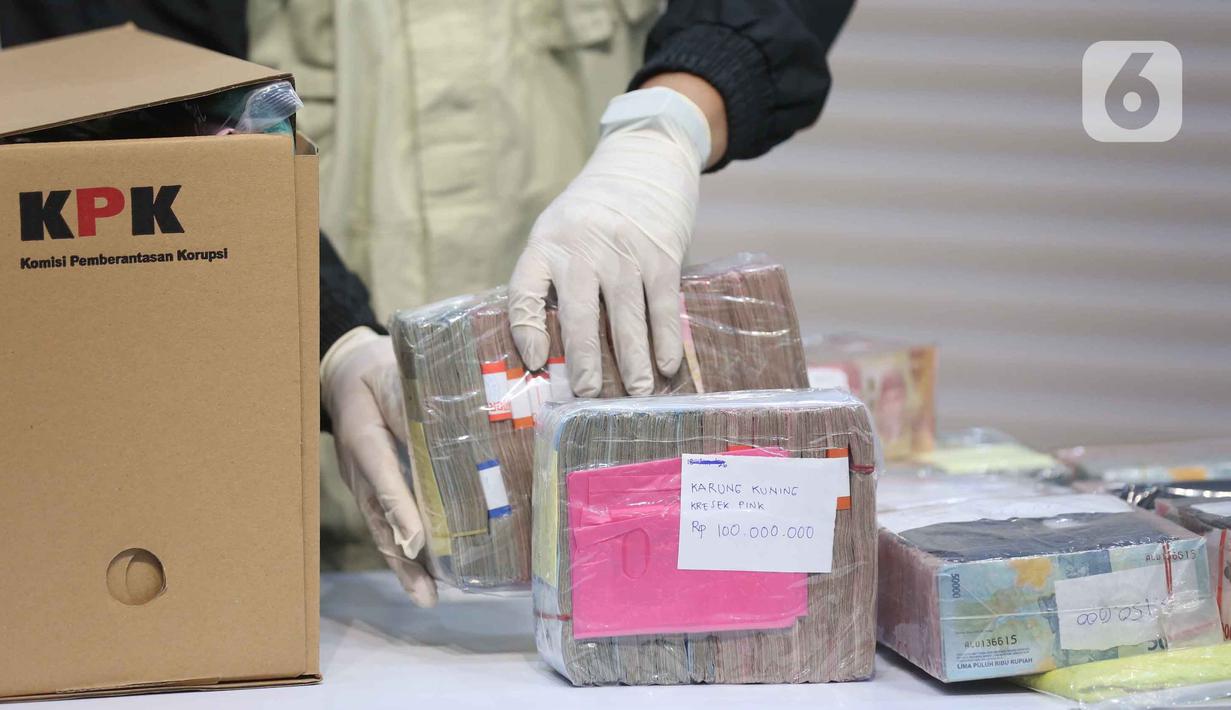 Petugas menyusun tumpukan uang barang bukti Operasi Tangkap Tangan (OTT) Bupati Pati Sudewo di Gedung Merah Putih Komisi Pemberantasan Korupsi (KPK), Jakarta, Selasa (20/1/2026). (Liputan6.com/Helmi Fithriansyah)