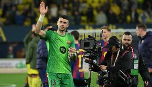 Kiper Barcelona, Joan Garcia, melakukan lima penyelamatan saat timnya bersua Villarreal pada laga pekan ke-17 La Liga di Estadio de la Ceramica, Minggu (21/12/2025) malam WIB. Berkat kontribusi Garcia, Barca menang 2-0 atas Villarreal. (AFP/Jose Jordan)