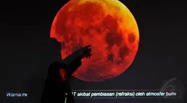 Seorang petugas menerangkan gambaran proses gerhana bulan total di Planetarium Taman Ismail Marzuki, Jakarta, (8/10/14).(Liputan6.com/Johan Tallo) 