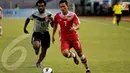 Pemain Laos, Khonesavanh Sihavong (nomor 7) berebut bola dengan pemain Papua Nugini Sengum Maximilion saat bertanding yang digelar Minggu (24/11/13) di GBK, Jakarta (Liputan6.com/Helmi Fithriansyah)
