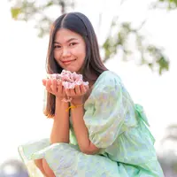 ilustrasi perempuan memegang bunga/Makhh/Shutterstock