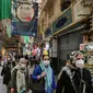 Para pembeli mengenakan masker dan sarung tangan lateks, akibat pandemi coronavirus COVID-19, berjalan di pasar Tajrish selama bulan suci Ramadan di Taheran, Iran (25/4/2020). (AFP/Atta Kenare)