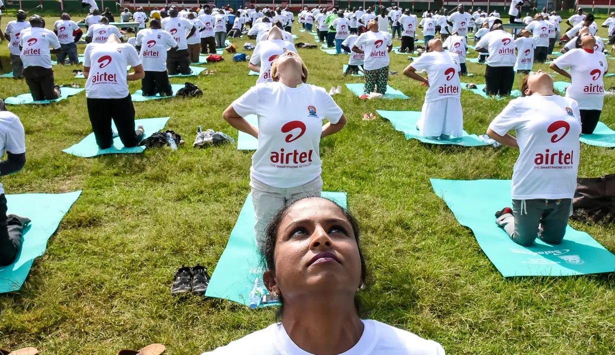 Ratusan warga melakukan gerakan yoga saat mengikuti sesi yoga massal di Stadion Afraha di Nakuru, Kenya (15/6/2019). Acara yoga massal ini untuk memperingati Hari Yoga Internasional. (AFP Photo/Suleiman Mbatiah)