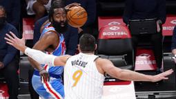 Pebasket Brooklyn Nets, James Harden, berusaha melewati pebasket Orlando Magic, Nikola Vucevic, pada laga NBA, Sabtu (16/1/2021). Nets menang dengan skor 122-115. (AP Photo/Mary Altaffer)