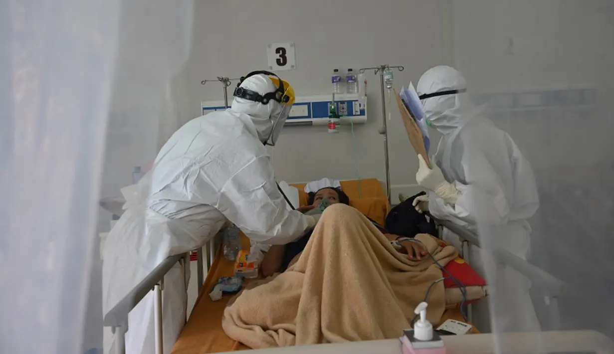Petugas medis memeriksa pasien COVID-19 di rumah sakit umum di Bogor, Jawa Barat, Senin (25/1/2021). Angka kasus COVID-19 di Kota Bogor pada masa pemberlakuan pembatasan kegiatan masyarakat (PPKM) terus meningkat. (ADEK BERRY/AFP)