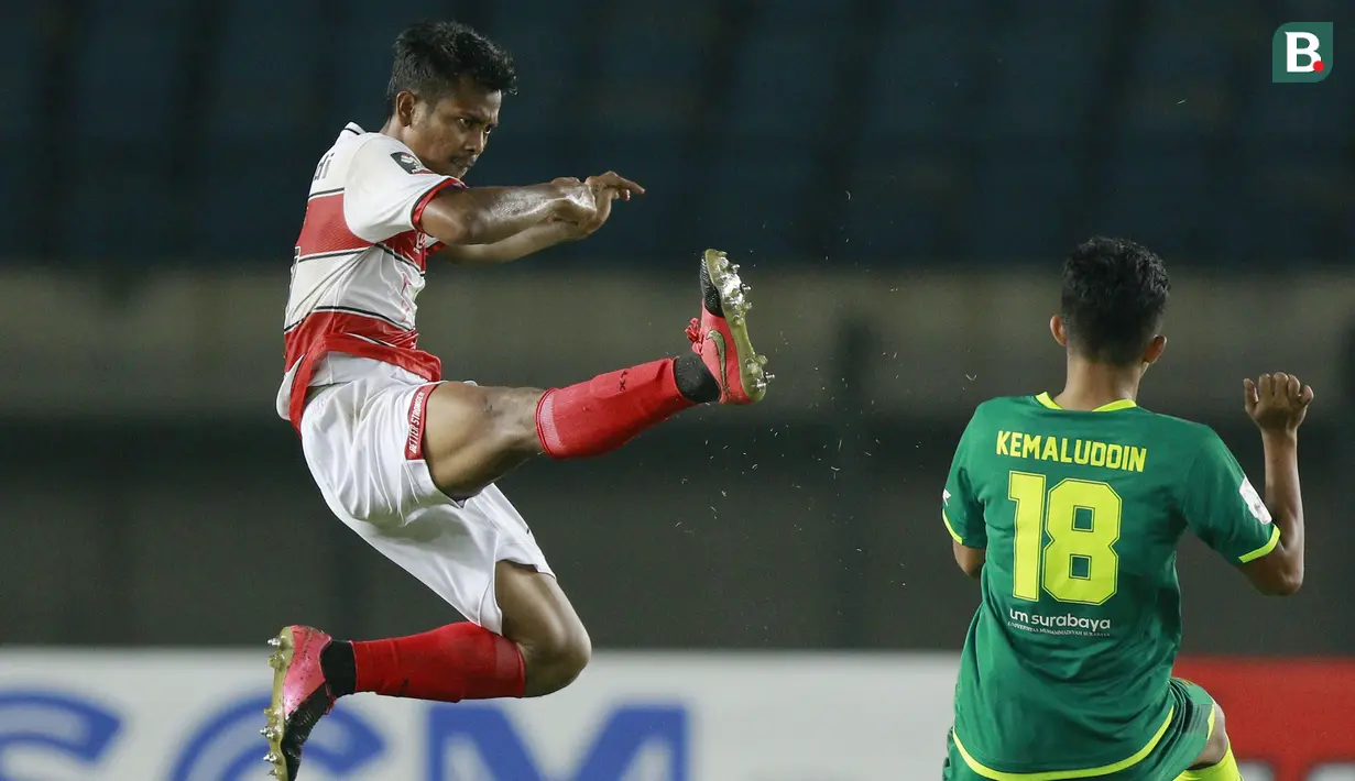Gelandang Madura United, Zulfiandi (kiri) berebut bola dengan gelandang Persebaya Surabaya, Muhammad Kemaluddin dalam laga matchday ke-2 Grup C Piala Menpora 2021 di Stadion Si Jalak Harupat, Bandung, Minggu (28/3/2021). Madura United kalah 1-2 dari Persebaya. (Bola.com/M Iqbal Ichsan)