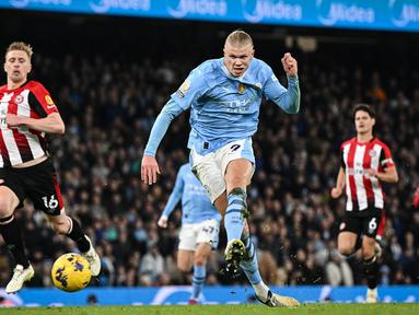 Pemain Manchester City, Erling Haaland mencetak gol ke gawang Brentford pada laga lanjutan Liga Inggris 2023/2024 di Etihad Stadium, Manchester, Inggris, Rabu (21/02/2024) dini hari WIB. (AFP/Paul Ellis)