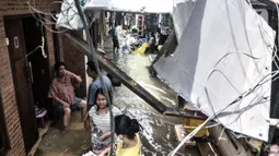 Warga beraktivitas di tengah banjir yang merendam permukiman warga di Kemang Timur XI, Jakarta, Minggu (21/2/2021). Ketinggian air mencapai sepinggang orang dewasa. (merdeka.com/Iqbal S. Nugroho)