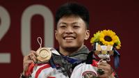 Lifter Indonesia, Rahmat Erwin Abdullah menyumbang medali ketiga bagi Indonesia dari cabang angkat Besi kelas 73 kg putra di Olimpiade Tokyo 2020, Rabu (28/7/2021). Ia meraih medali perunggu usai menempati posisi teratas di Grup B, dan ketiga secara keseluruhan. (Foto: AP/Luca Bruno)