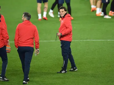 Pelatih Sevilla Vincenzo Montella (kanan) dan asistennya melihat para pemainnya latihan di stadion Old Trafford di Manchester, Inggris (12/3). Sevilla akan melawan Manchester United pada leg kedua babak 16 besar Liga Champions. (AFP Photo/Oli Scarff)
