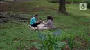 Warga membawa bekal makanan sambil menggelar tikar saat berwisata di Tebet Eco Park, Tebet, Jakarta, Senin (15/4/2024). (Liputan6.com/Herman Zakharia)