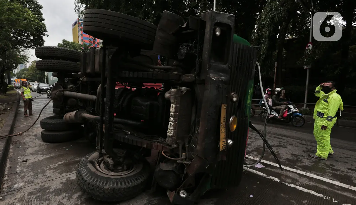 Petugas melakukan evakuasi Kontainer yang terguling di Jalan S Parman, Jakarta Barat, Senin (4/5/2020). Tidak ada korban jiwa dalam kecelakaan tersebut, namun kecelakaan tersebut membuat lalin dijalan itu terimbas kemacetan yang cukup panjang. (Liputan6.com/Johan Tallo)