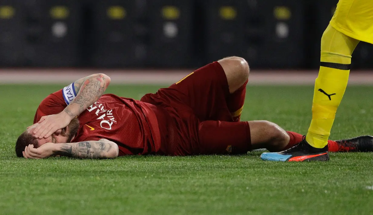 Pemain AS Roma, Daniele De Rossi terbaring kesakitan saat bertanding melawan AC Milan pada laga pekan ke-22 Serie A di Stadion Olimpico, Roma, Italia, Minggu (3/2). AS Roma  menahan imbang AC Milan 1-1. (AP Photo/Gregorio Borgia)