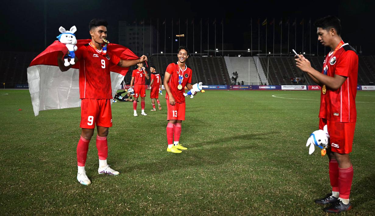 Sejumlah pemain Timnas Indonesia U-22 merayakan kemenangan pada laga final sepak bola SEA Games 2023 melawan Thailand di Olympic Stadium, Phnom Penh, Kamboja, Selasa (16/05/2023). Skuad Garuda Nusantara menang dengan skor 5-2. (AFP/Mohd Rasfan)
