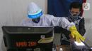 Petugas Dukcapil lengkap dengan APD memindai sidik jari KTP Elektronik di Kecamatan Pamulang, Tangerang Selatan, Senin (15/6/2020) Dukcapil Tangsel membuka layanan rekaman E-KTP jelang Pilkada dengan menerapkan ketentuan New Normal guna mencegah penyebaran Virus Covid-19. (Liputan6.com/Fery Pradolo)