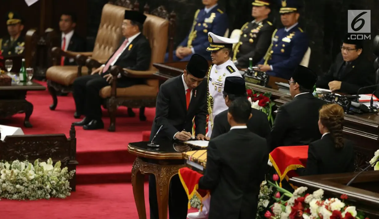 Presiden Joko Widodo disaksikan Ketua DPD RI Oesman Sapta Odang dan Wakil Ketua DPR Fadli Zon saat menandatangani Nota Keuangan dan RAPBN 2018 di Kompleks Parlemen, Senayan, Jakarta, Rabu (16/8). (Liputan6.com/Johan Tallo)