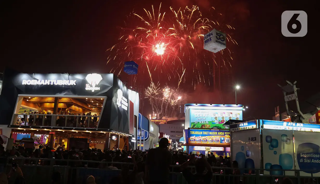Pengunjung menyaksikan pesta kembang api di langit saat Jakarta Fair ke-53 atau Pekan Raya Jakarta (PRJ) di JiExpo Kemayoran, Jakarta Pusat, Selasa (21/6/2022) malam. Pesta kembang api menggelegar di kawasan PRJ bertepatan dengan HUT Jakarta yang jatuh pada besok, 22 Juni 2022. (Liputan6.com/Herman Zakharia)