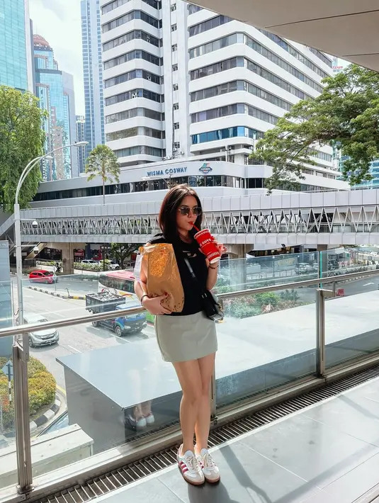 Gaya chic Marsha Aruan pakai kaus hitam lengan pendek dengan mini skirt abu-abu, sneakers putih, dan sunglasses. [Foto: Instagram/aruanmarsha]