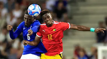 Gelandang Prancis #06 Manu Kone (Kiri) berebut bola dengan penyerang Guinea #12 Algassime Bah pada matchday 2 Grup A sepak bola Olimpiade Paris 2024 di stadion Allianz Riviera, Minggu (28/7/2024). (Valery HACHE / AFP)