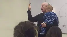 Sebuah foto seorang dosen mengajar sambil menggendong bayi menjadi bahan pembicaraan berbagai kalangan di media sosial.