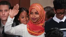 Senator Amerika Serikat (AS) Ilhan Omar melambaikan tangan saat mengikuti pelantikan di Gedung Kongres AS, Capitol, Washington, Kamis (3/1). Omar adalah perempuan berhijab pertama yang masuk ke Senat AS. (Glen Stubbe/Star Tribune via AP)